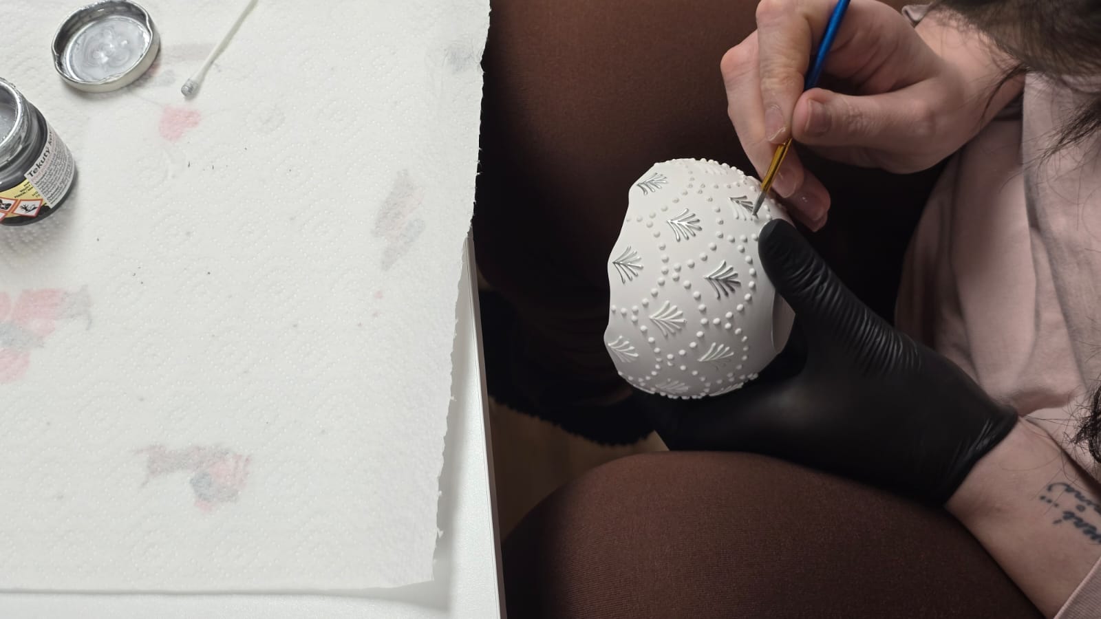 Deuxième détail de l'application manuelle d'ornements sur le vase de la bougie