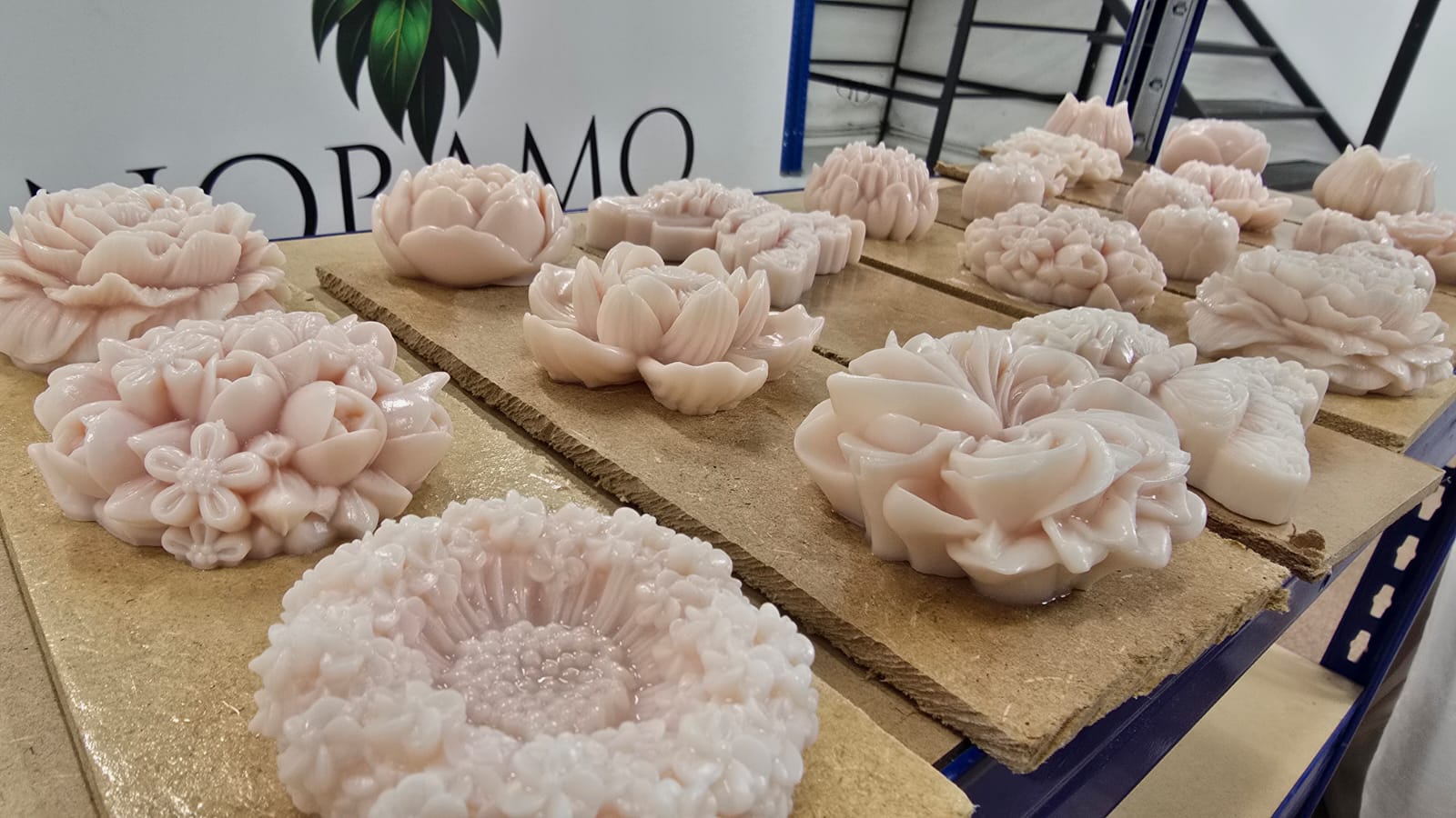 Bougies en forme de fleurs et de vases décoratifs prêtes à être placées sur une étagère