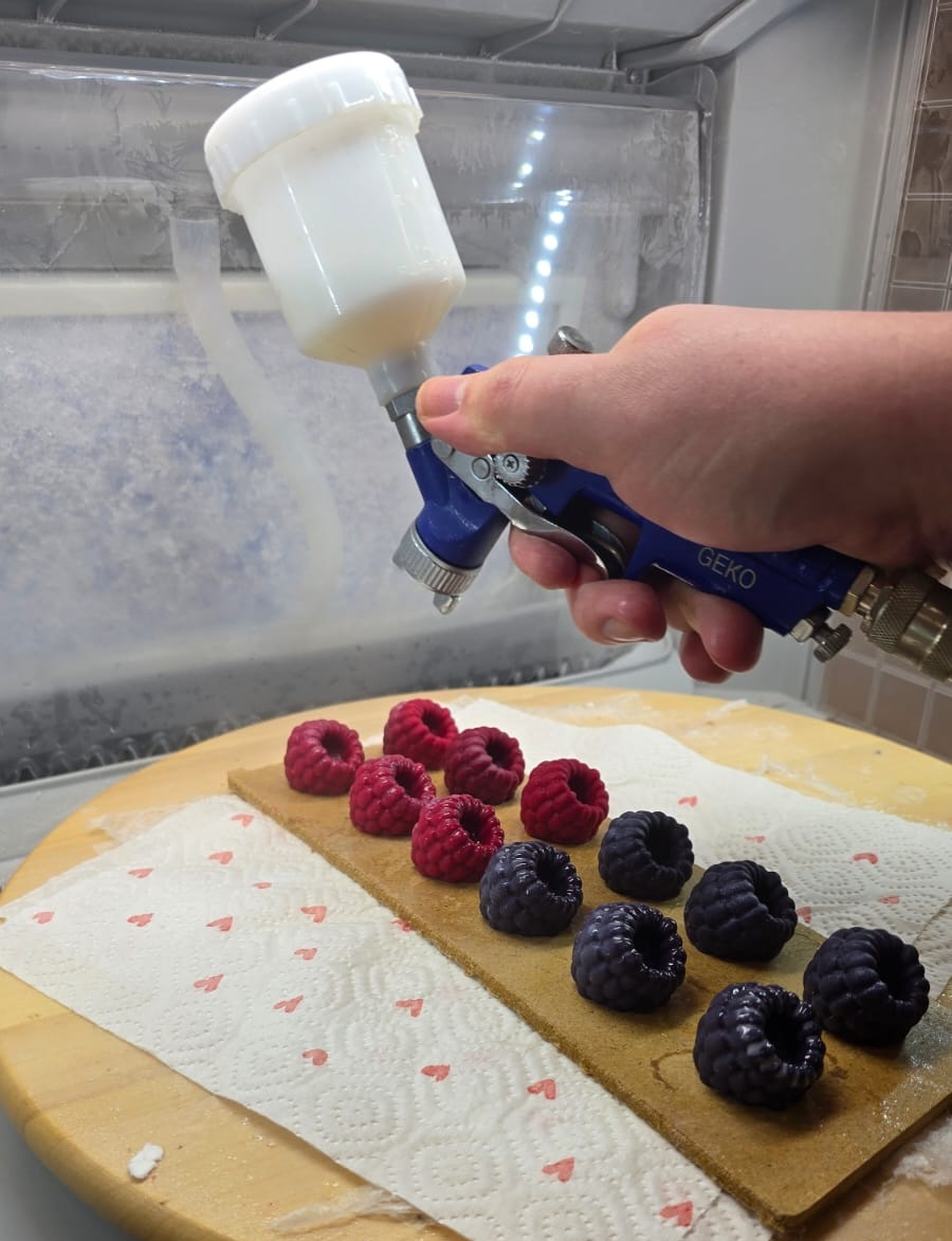 Pulvérisation de vernis sur une bougie en cire dans une cabine de peinture