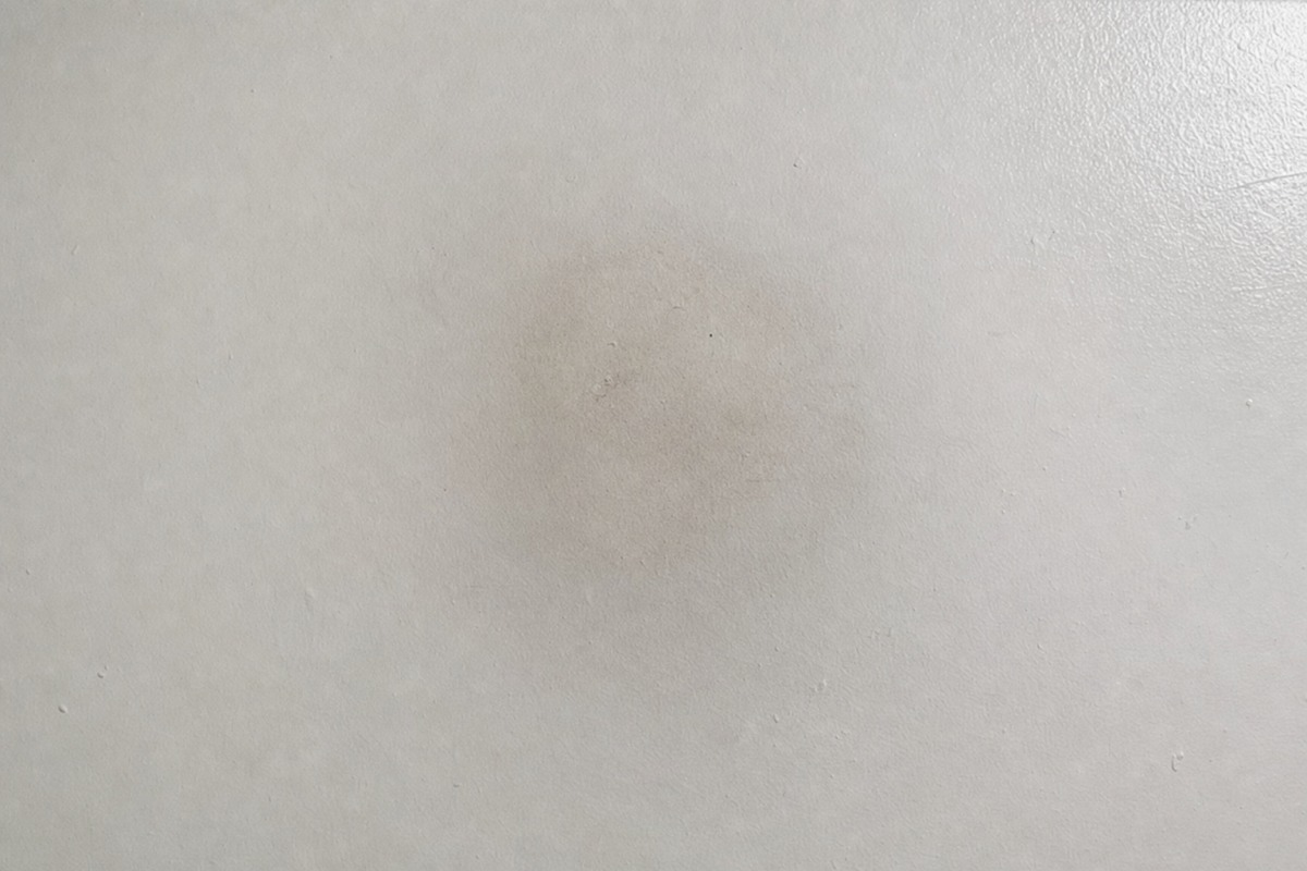 Légère ombre grise de suie sur un plafond blanc, à l'endroit où se dressait une bougie à la paraffine